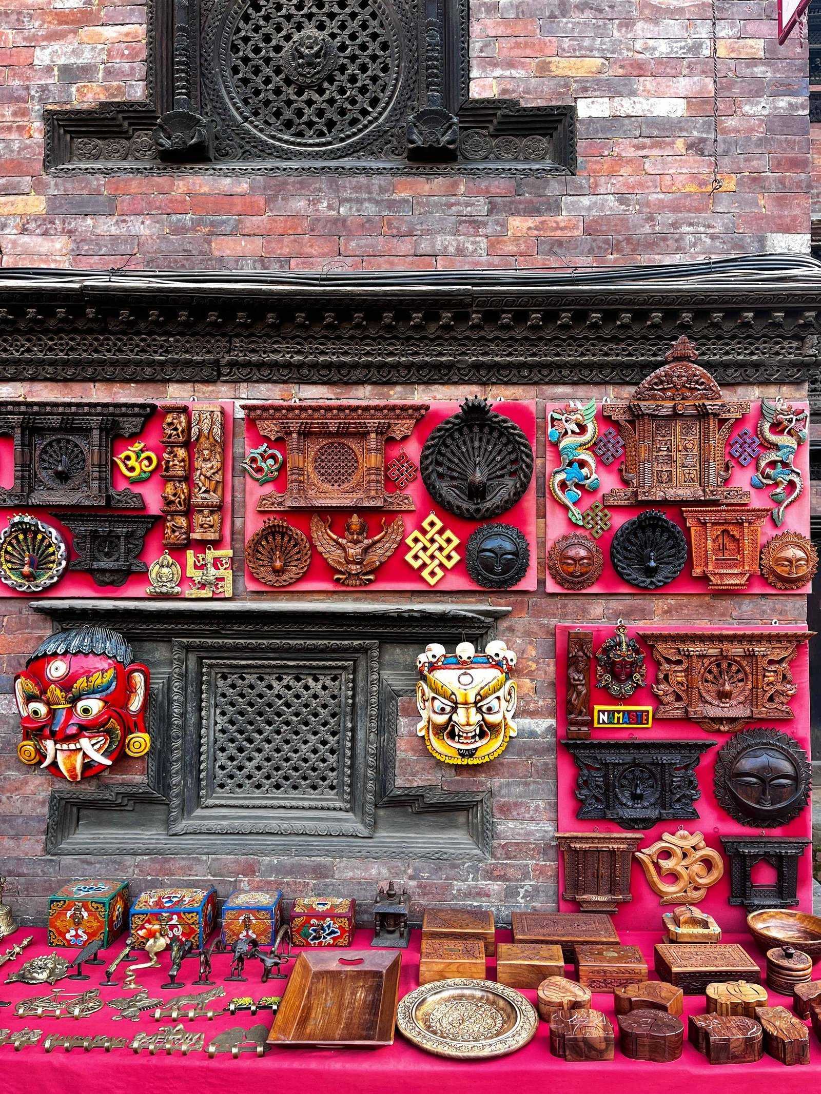 Colorful display of traditional Nepali handicrafts in Bhaktapur's market, featuring masks and wood carvings.